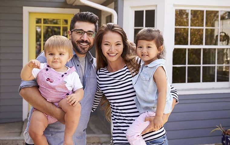 Keep Your Family Healthy With Pest Control a happy family of four in front of their house in essex