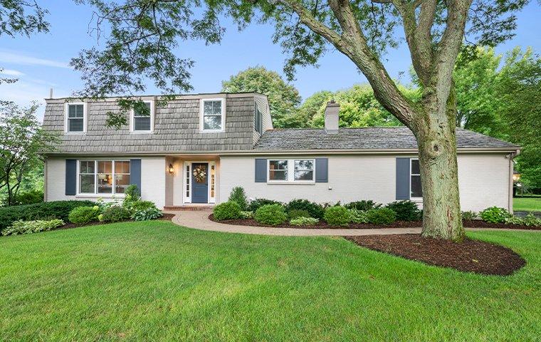 a white two story house with a big green yard