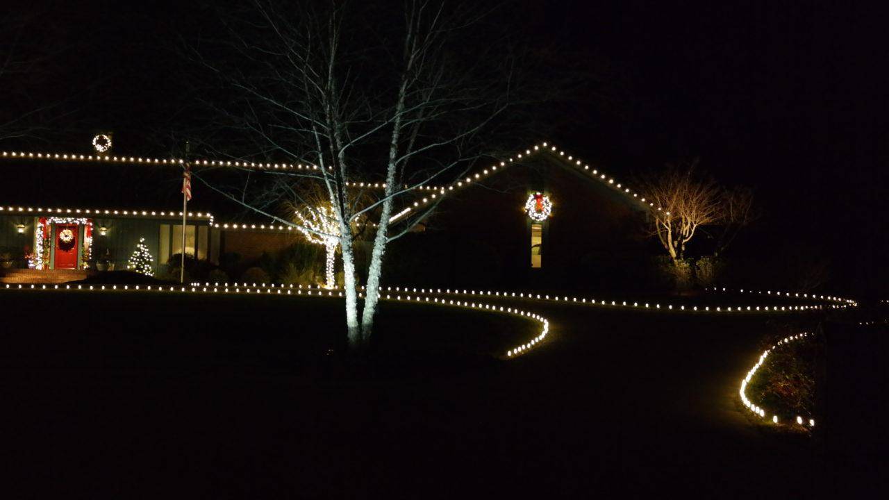 a house with christmas lights lining the driveway