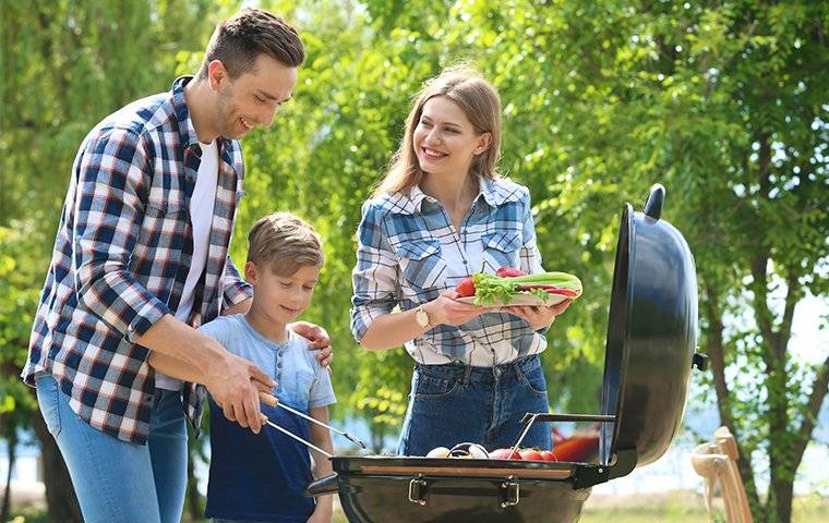 family cooking food on a grill