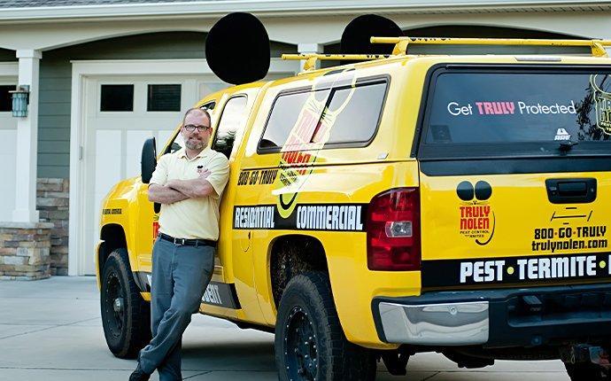 a truly nolen service technician beside a company truck