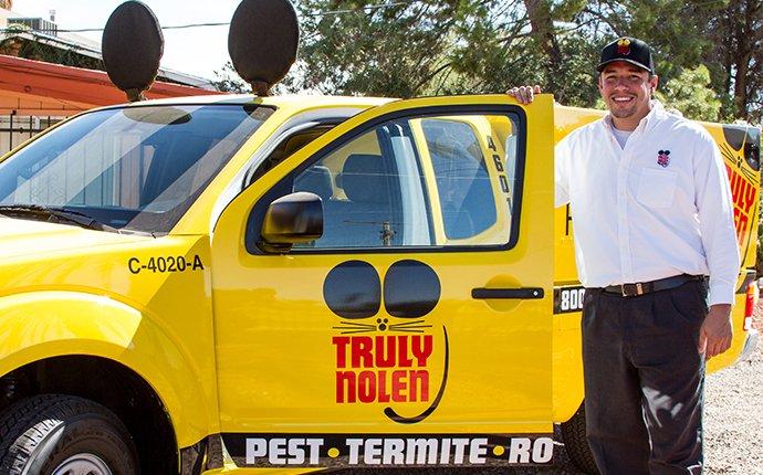 a truly nolen technician next to a company truck