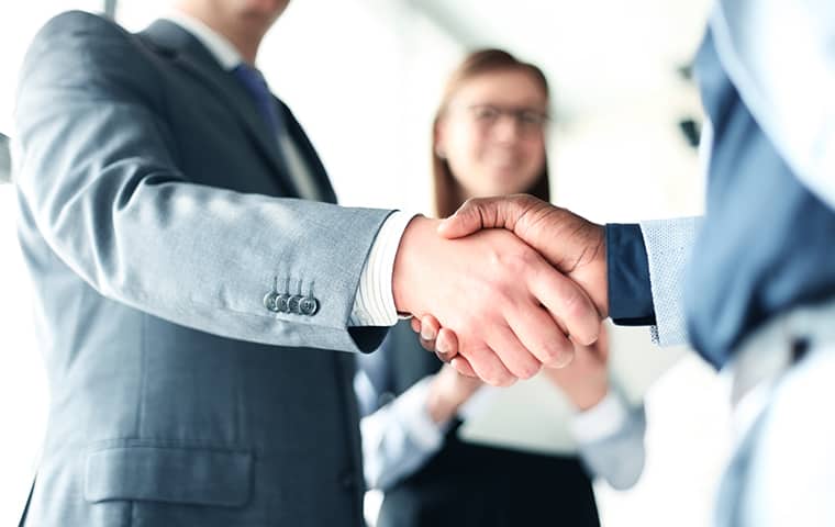 There Are Many Benefits To Owning A Franchise two businessmen shaking hands inside an office in san antonio texas