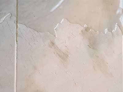 water collecting on floor beside tub