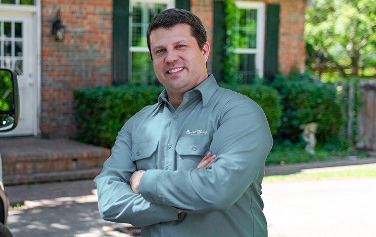 a pest expert in front of a house