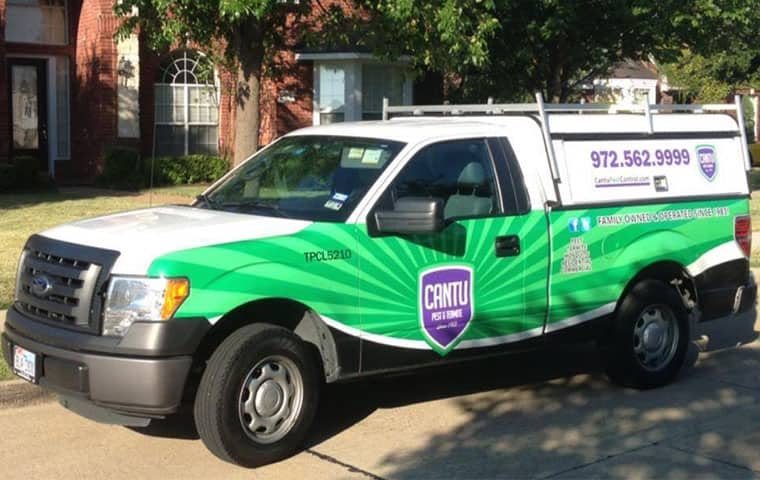 a cantu pest control company car parked outside of a home in houston texas