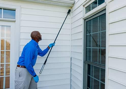 a technician performing an exterior home treatment in colesville maryland