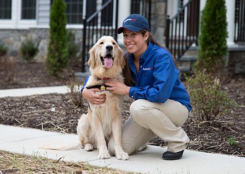 Our Pest Control Services Have Earned Us A BBB A+ Rating a service technician smiling with a k9 inspection dog in falls church virginia