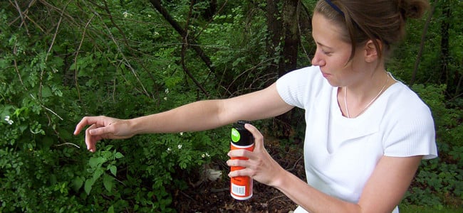 woman applying bug spray correctly