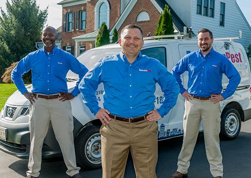 We've Earned The QualityPro Seal Of Excellence From NPMA three service technicians in front of a home in daniels maryland