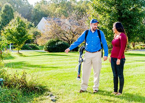 a technician inspecting a yard with a customer in maryland