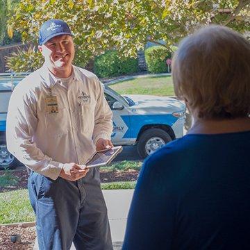 a pest technician speaking with a customer