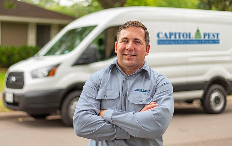 It's Our Goal To Exceed Your Expectations a pest technician standing by his service vehicle in washington dc