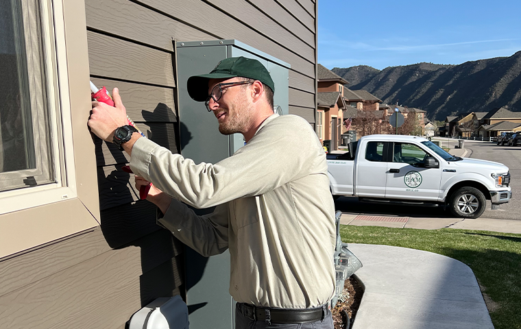 a ram wildlife and pest management service technician treating a home in de beque colorado