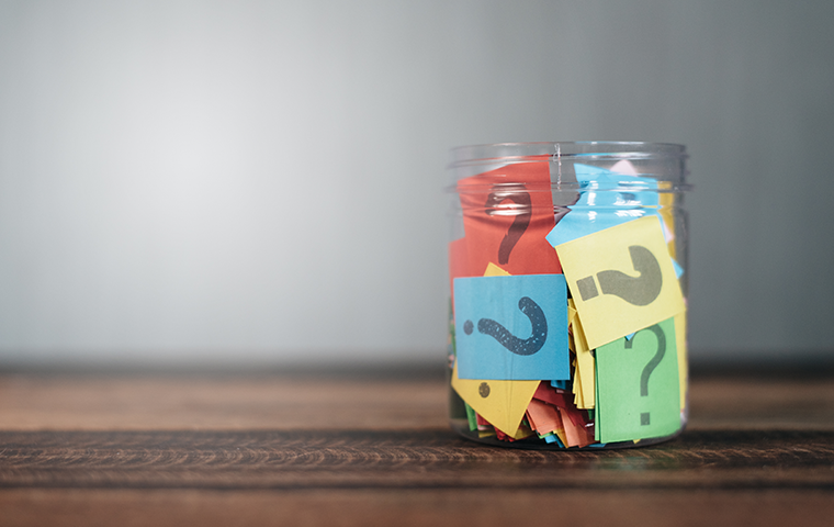 clear jar with colorful paper with question marks on them
