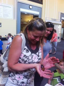 Woman holds hissing cockroach at Koch Family Children Museum woman holding hissing cockroach