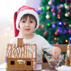 young boy decorating gingerbread house
