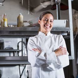 chef standing in front of kitchen with arms crossed