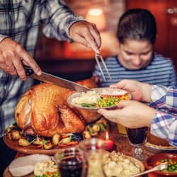 family siting around a table carving a turkey