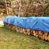 stack of wood outside covered by a tarp