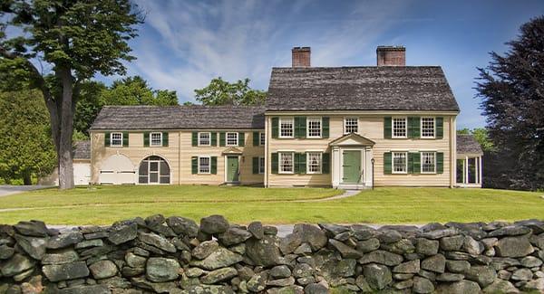 house with stone wall in front of it