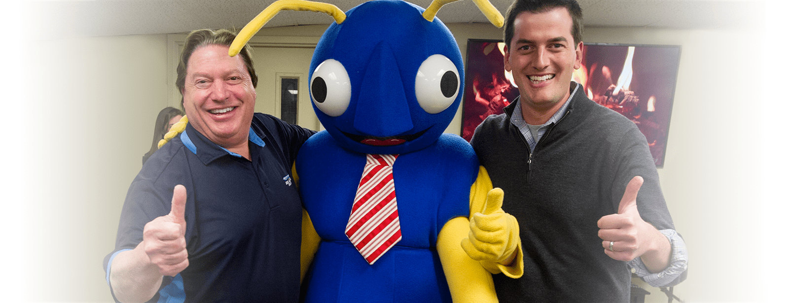 two employees with big blue bugs mascot, nibbles