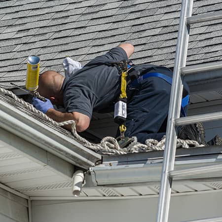 wildlife control technician patching holes in a ri roof