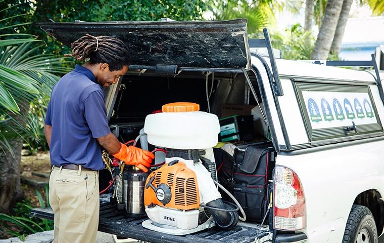 technician gathering mosquito control gear at home on grand turk island