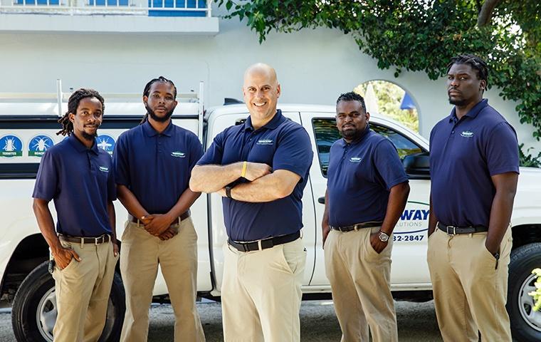 the turks and caicos pest experts standing beside a service vehicle