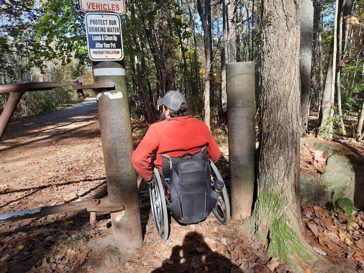 Enock sneaking through the pillars next to the gated entrance to the trail. Photo credit: Enock Glidden