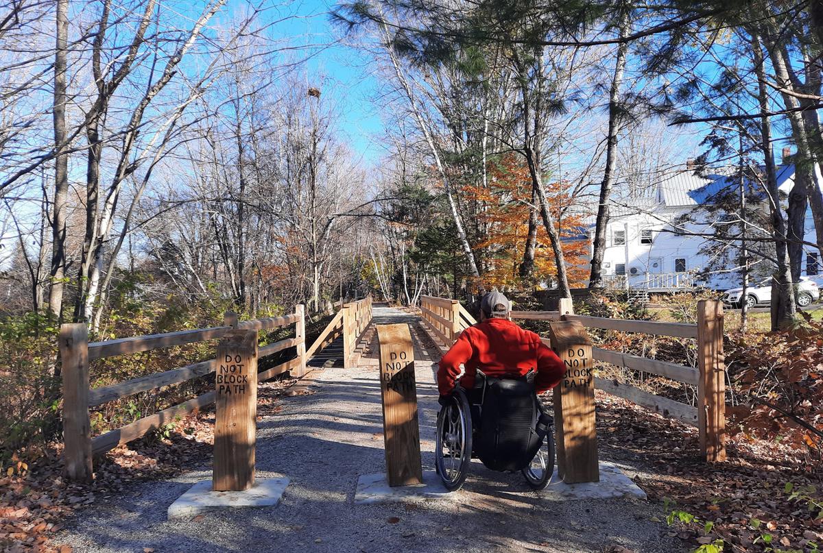 Enock with his wheelchair wheels on the concrete blocks between the pillars. Photo credit: Enock Glidden