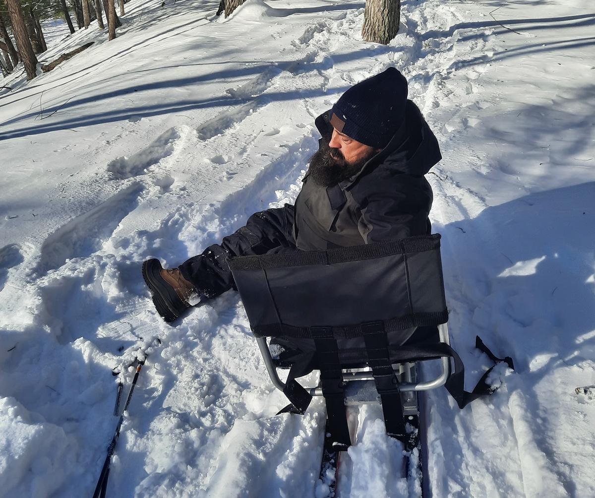 Enock getting back into the sit-ski after a close encounter with the snow. Photo credit: Enock Glidden