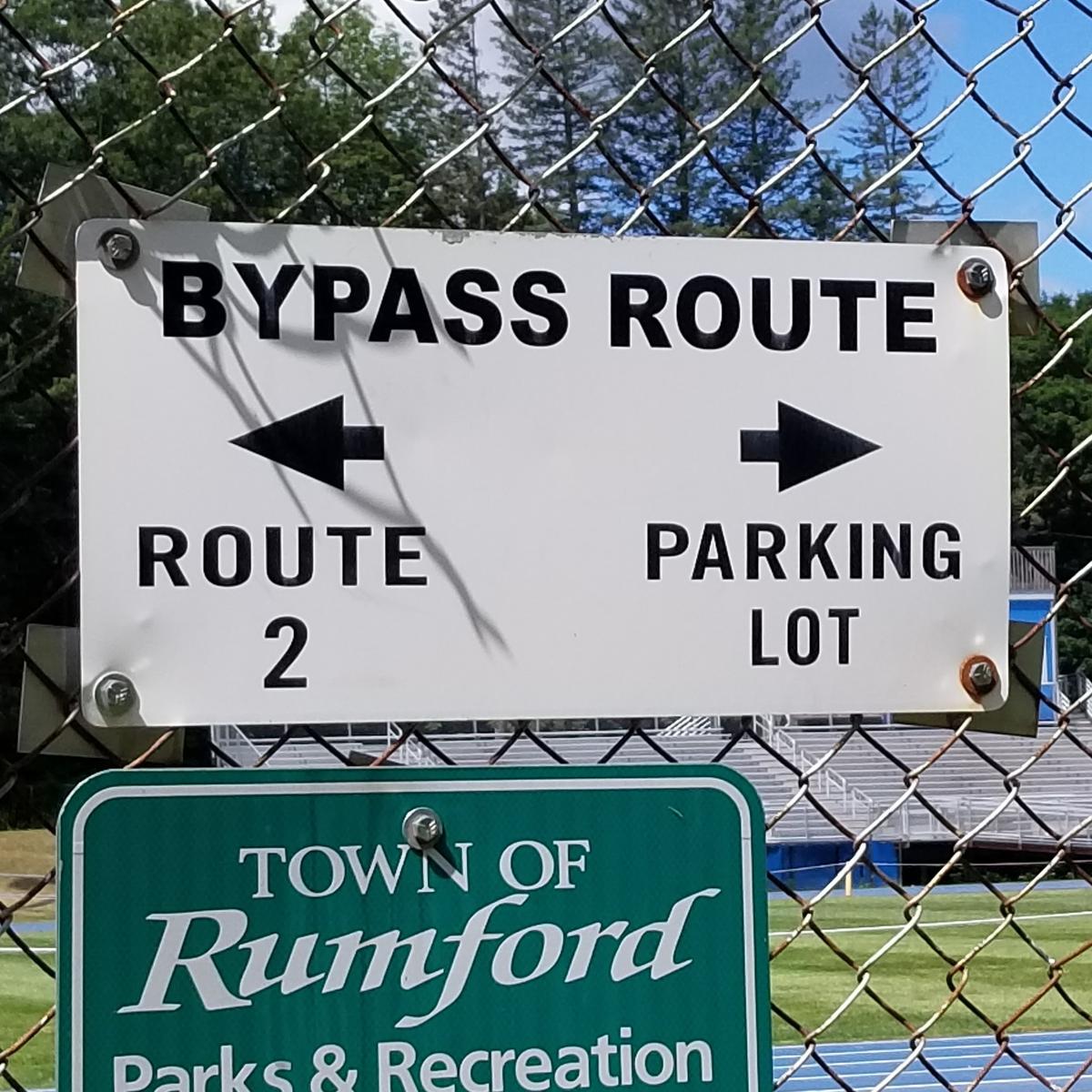 Sign at the end of the trail indicating where to turn to reach the parking lot.