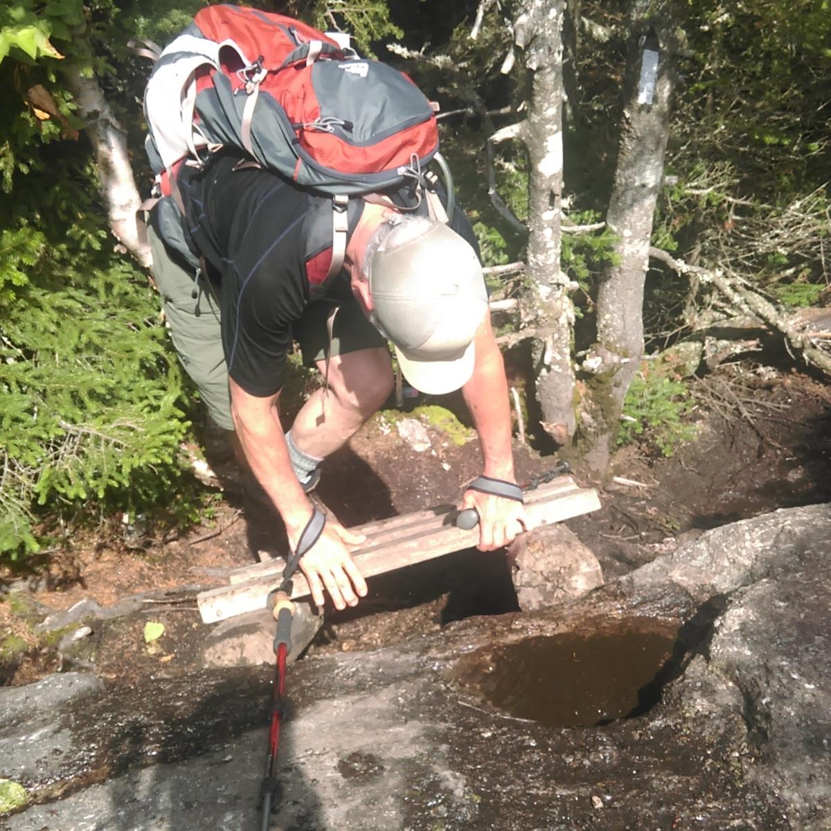 A hiker descends on a ladder