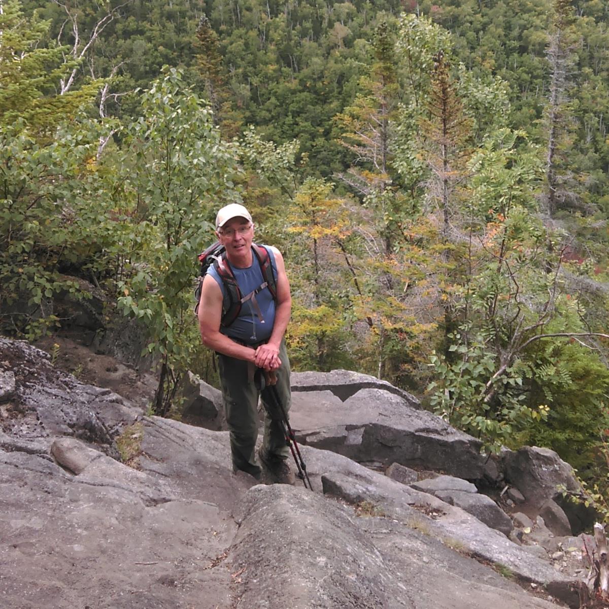 a hiker looks up a trail on an exposed rock face