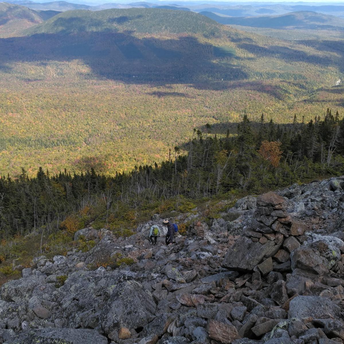 Hikers descend an extremely rocky section of trail