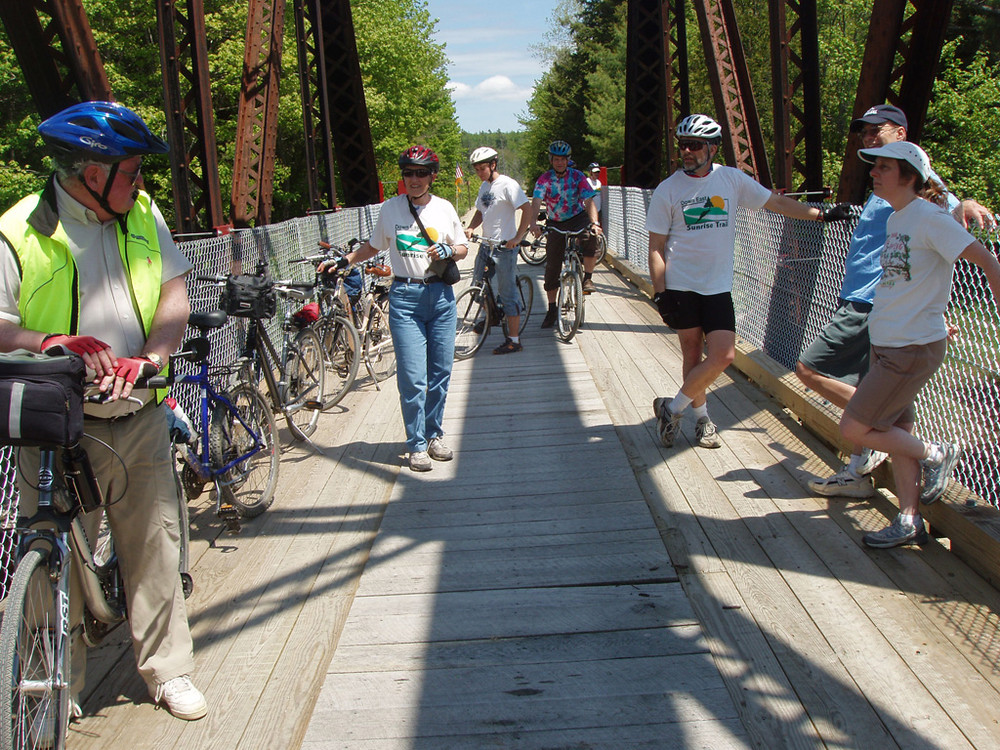 Cyclists Enjoy the view over the Machias River in Whitneyville (Credit: Sunrise Trail Coalition)