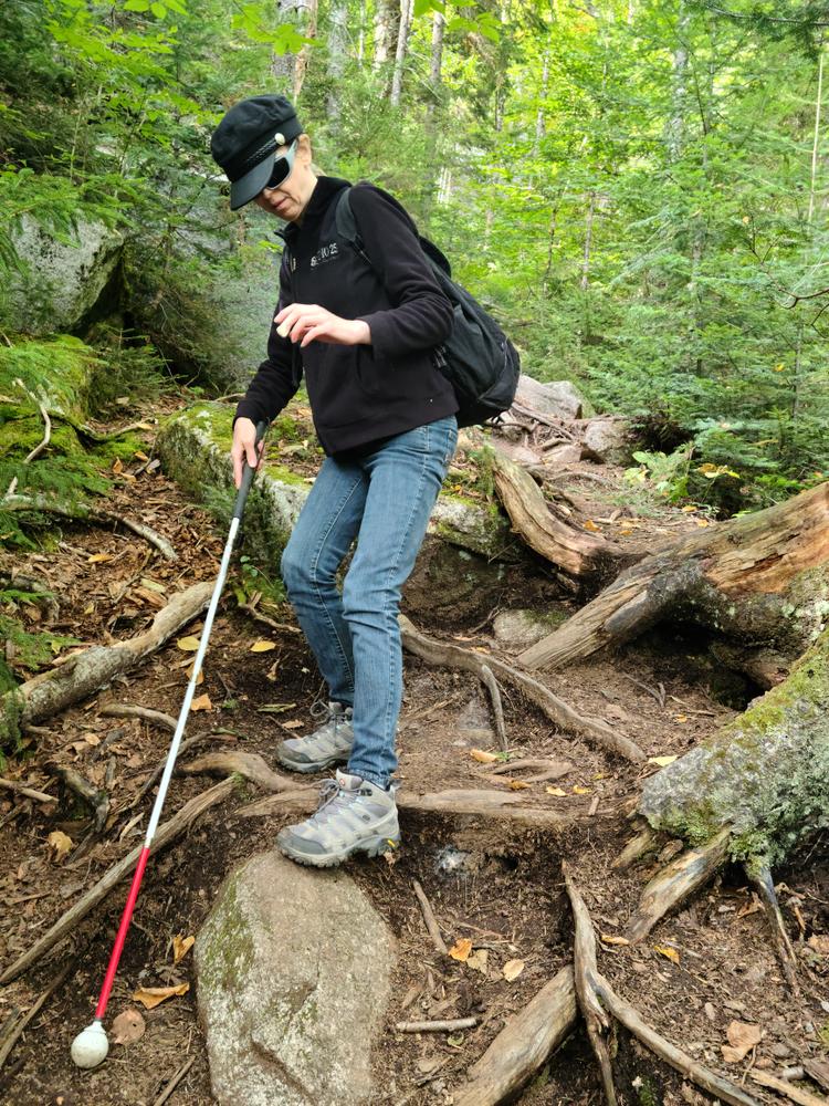 That's not a trekking pole, it's her "cane" that she uses to feel out the trail. She is legally blind. (Credit: Brian Marston)