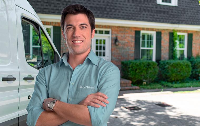 a pest expert in front of a house