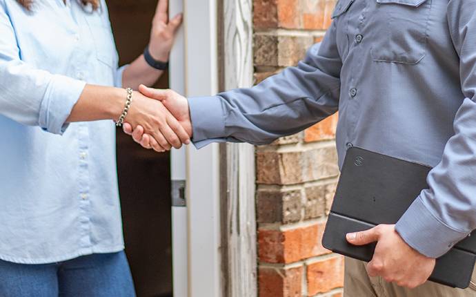 a tech shaking hands with a homeowner