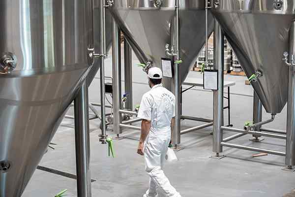 tech inspecting inside brewery
