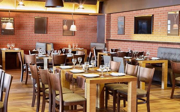 tables and chairs set up inside of a restaurant requiring commercial pest control