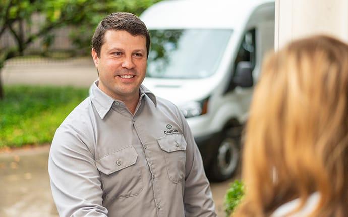 Our Technicians Are Friendly And Local pest control technician greeting a homeowner in cadillac maine