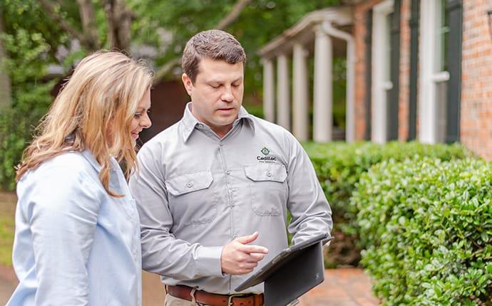 Our Follow Up Services Make Sure Pests Are Gone pest control technician talking with homeowner using software in cadillac maine