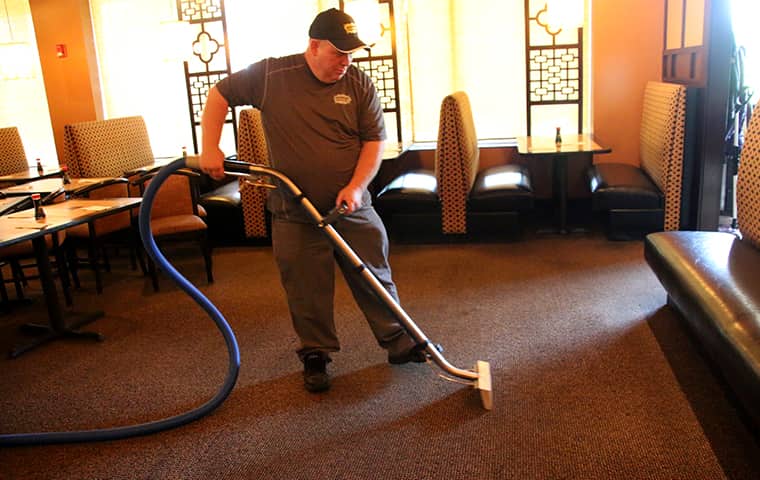 an augustine exterminators servie technician performing professional carpet cleaning inside of a kansas city commercial business