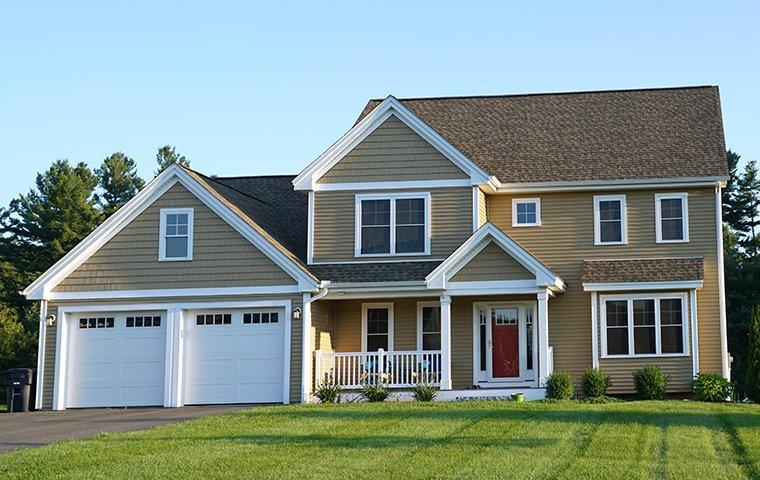 a tan two story house with attached garage