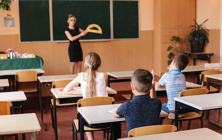 a classroom full of young children that are listening to their teacher