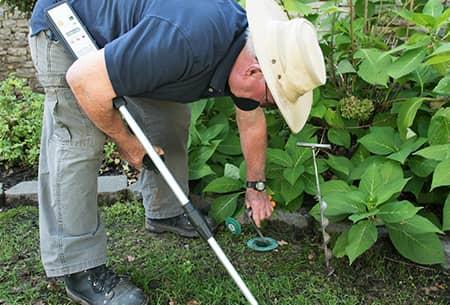 technician checking termite bait station