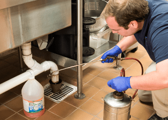 commercial pest control tech getting rid of pests in local business