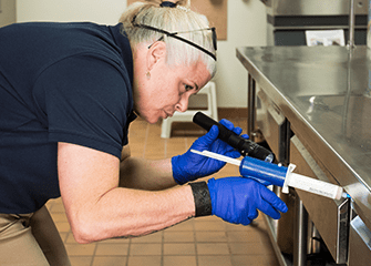 tech inspecting kitchen with business owner